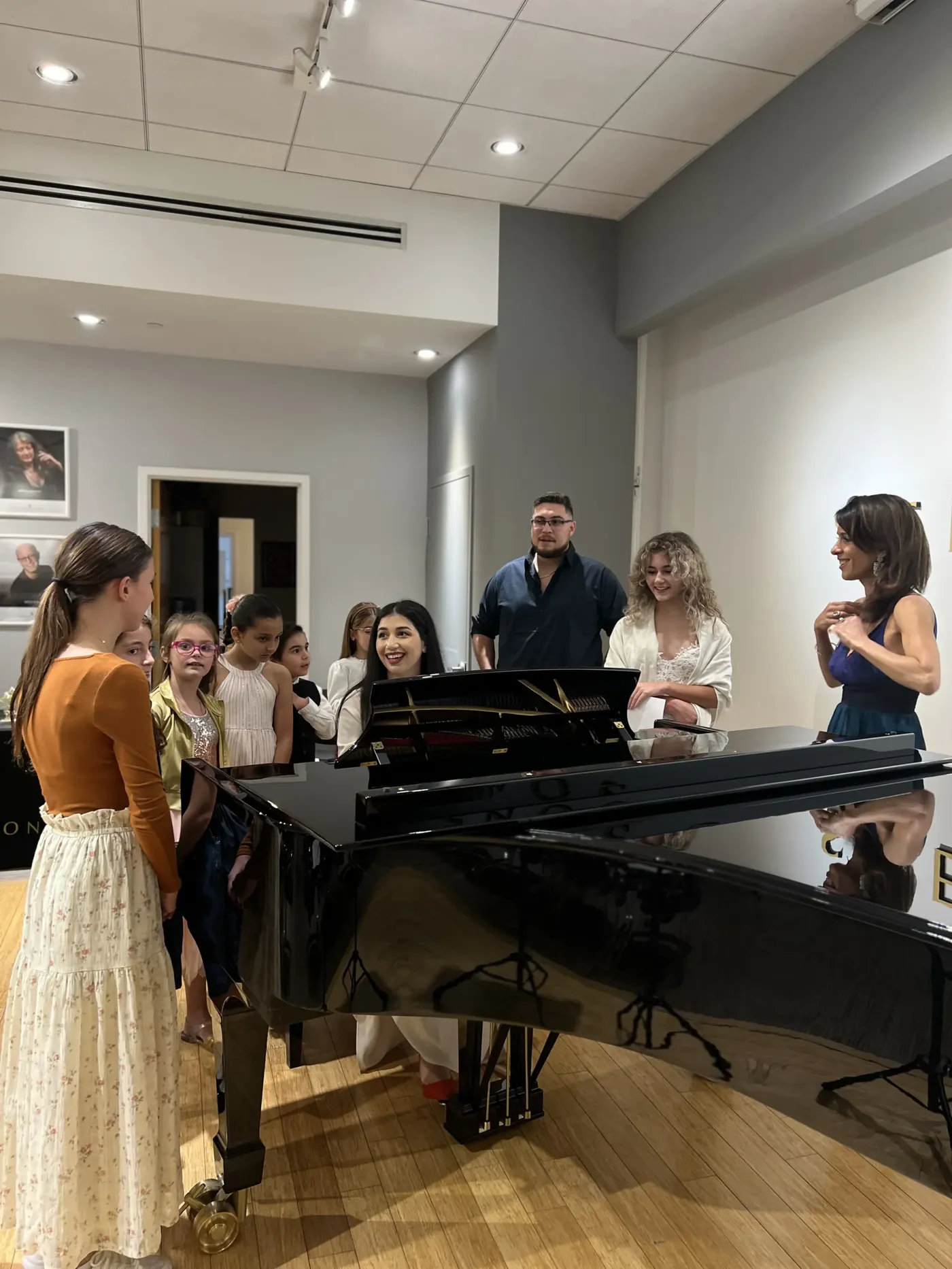 Students gathered around the piano at a recital
