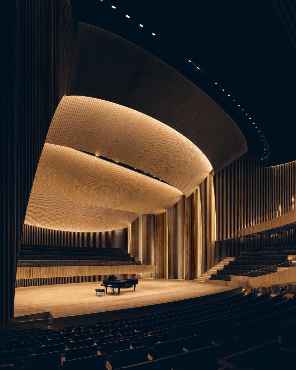 Empty concert hall interior with gilded balconies lit by a warm spotlight